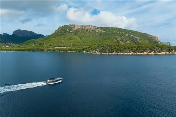 Voltor Yacht Photos Pics 2016 Riva 63 Virtus yacht cruising near lush coastal landscape.