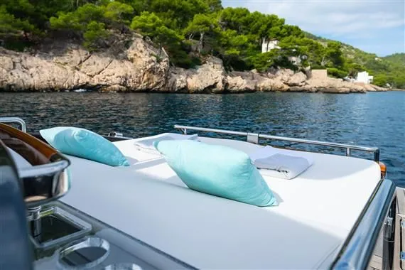 Voltor Yacht Photos Pics Luxurious sun deck of 2016 Riva 63 Virtus yacht with cushions, near rocky coastline.