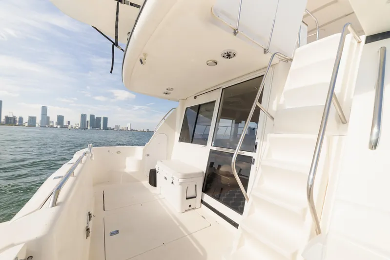 Salmonete Yacht Photos Pics 1999 Bayliner 5788 yacht deck with city skyline view, featuring stairs and seating area.