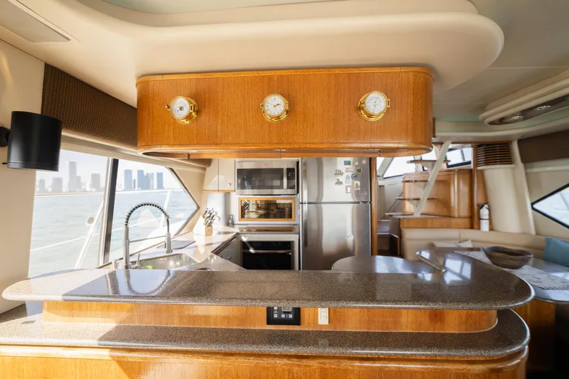 Salmonete Yacht Photos Pics Luxurious 1999 Bayliner 5788 yacht interior with modern kitchen and city skyline view.