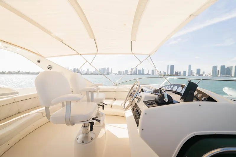Salmonete Yacht Photos Pics Luxurious 1999 Bayliner 5788 yacht helm with city skyline view, featuring white seating and controls.