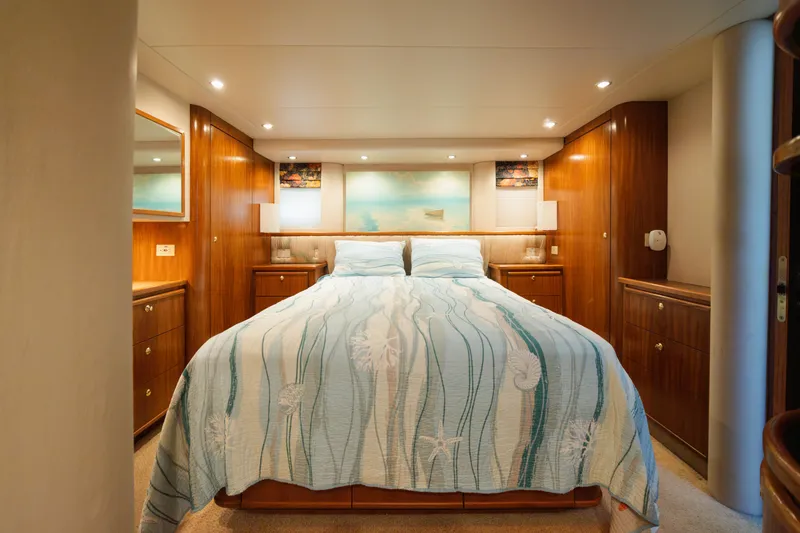 Salmonete Yacht Photos Pics Luxurious 1999 Bayliner 5788 yacht bedroom with elegant wood paneling and cozy bedding.