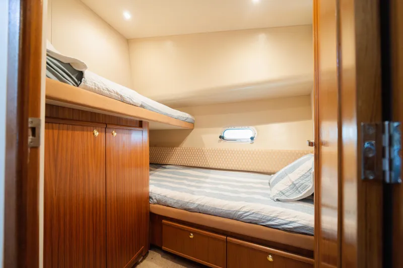 Salmonete Yacht Photos Pics Cozy cabin with bunk beds in 1999 Bayliner 5788 yacht, featuring wood paneling and porthole.