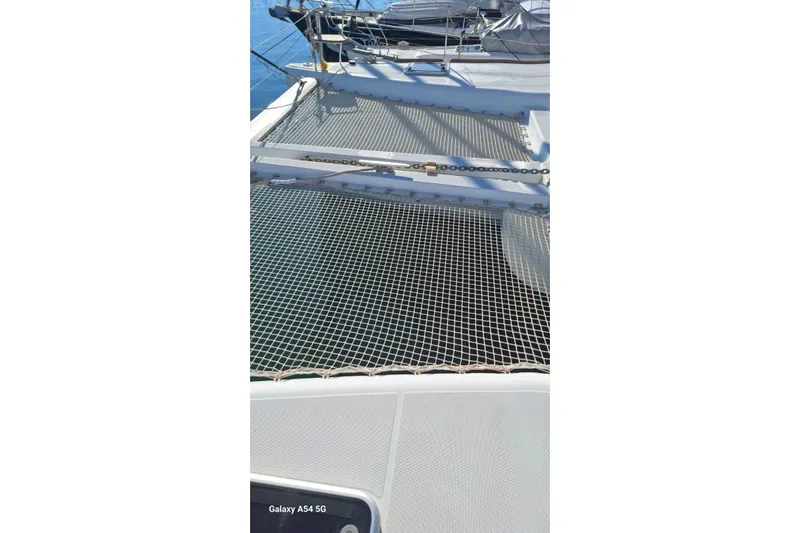  Yacht Photos Pics Catamaran deck with netting, Lagoon 450 F, 2018 model, on calm water.
