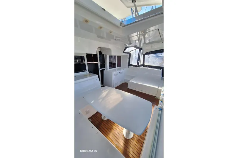  Yacht Photos Pics Interior view of 2018 Lagoon 450 F catamaran with sleek white furnishings and wooden flooring.