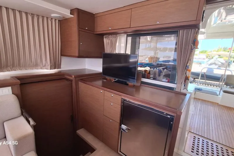  Yacht Photos Pics Interior of 2018 Lagoon 450 F yacht with TV, cabinets, and outdoor view.