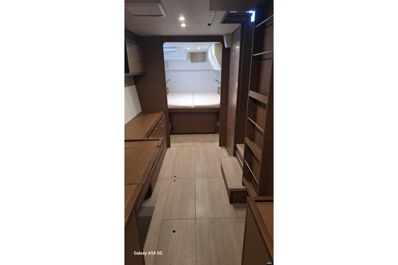  Yacht Photos Pics Interior of 2018 Lagoon 450 F yacht, featuring wood cabinetry and a cozy sleeping area.