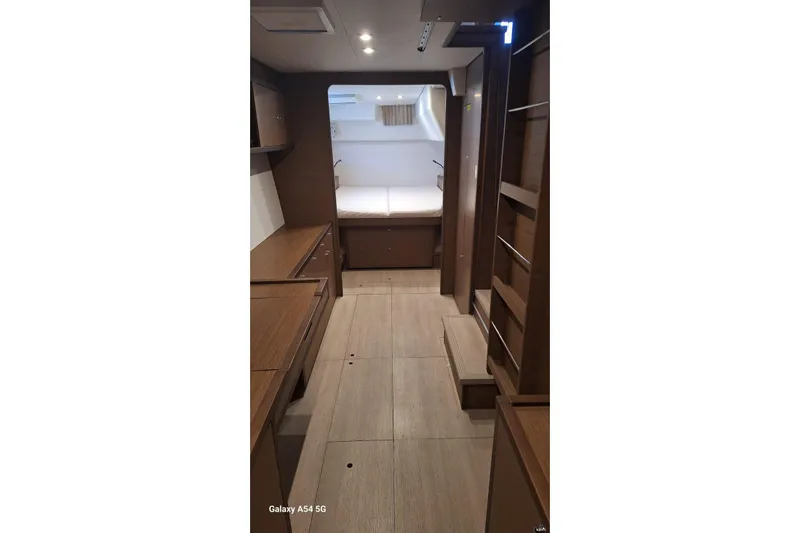  Yacht Photos Pics Interior of 2018 Lagoon 450 F yacht, featuring wooden cabinetry and a cozy sleeping area.