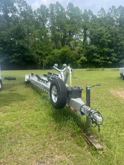 No Name Yacht Photos Pics Trailer for 2015 Cobia 344 Center Console on grassy field with trees in background.