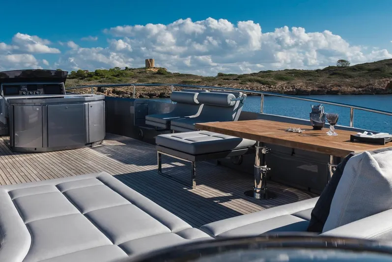 Aldebaran III Yacht Photos Pics Luxurious 2018 Pershing 108 yacht deck with elegant seating and dining area, overlooking serene waters.