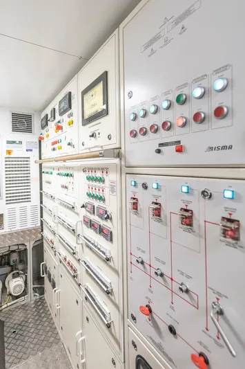 Aldebaran III Yacht Photos Pics Control room of a 2018 Pershing 108 yacht with various panels and switches.