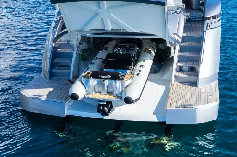 Aldebaran III Yacht Photos Pics 2018 Pershing 108 yacht with tender garage open, revealing inflatable boat on water.