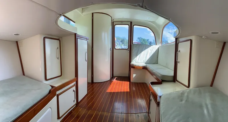 Legacy Yacht Photos Pics Interior of a 1973 Bertram 31 Flybridge Cruiser with wood flooring and cushioned seating.
