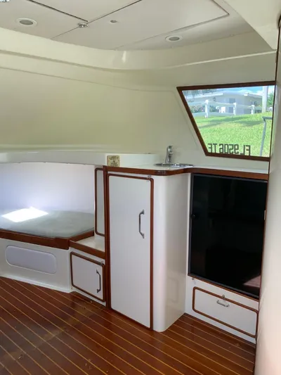 Legacy Yacht Photos Pics Interior of a 1973 Bertram 31 Flybridge Cruiser with wood flooring and compact kitchenette.