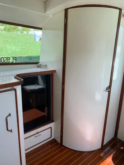 Legacy Yacht Photos Pics 1973 Bertram 31 Flybridge Cruiser interior with wood accents and curved door.