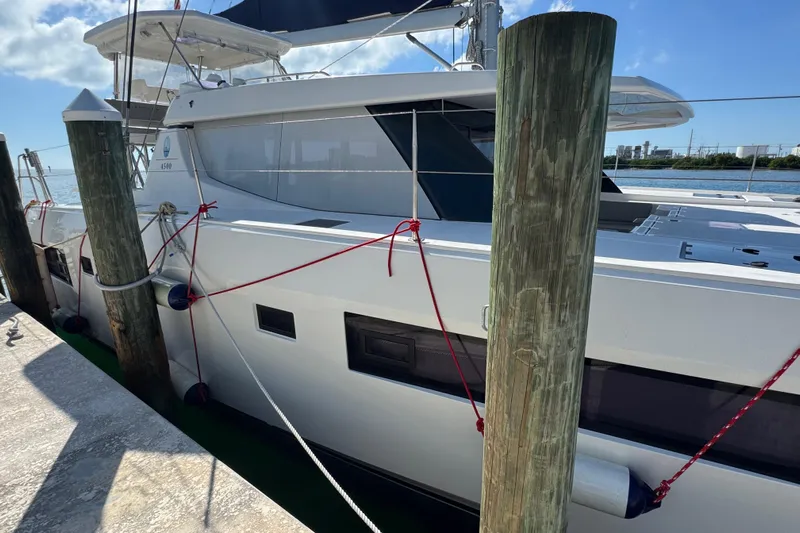 Ce Ya Yacht Photos Pics 2021 Leopard 45 catamaran docked at marina, side view with ropes and fenders.