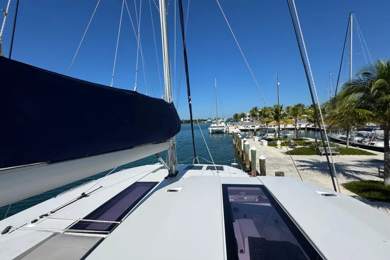 Ce Ya Yacht Photos Pics 2021 Leopard 45 catamaran docked at a sunny marina with palm trees.