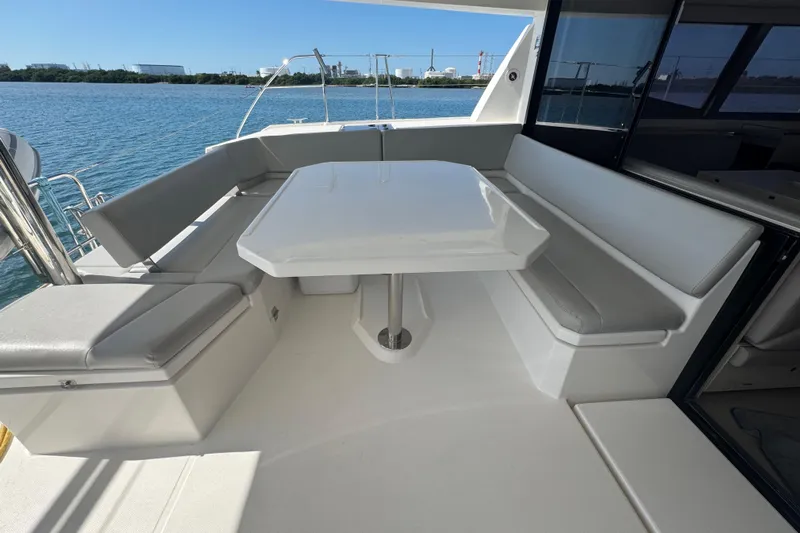Ce Ya Yacht Photos Pics Outdoor seating area on a 2021 Leopard 45 yacht with a table and cushioned benches.