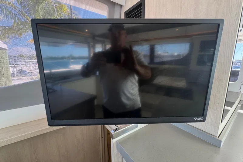 Ce Ya Yacht Photos Pics Vizio TV inside 2021 Leopard 45 yacht, reflecting interior and marina view.