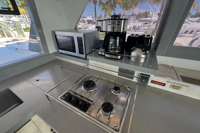 Ce Ya Yacht Photos Pics Modern kitchen in 2021 Leopard 45 yacht with stove, microwave, and coffee maker.