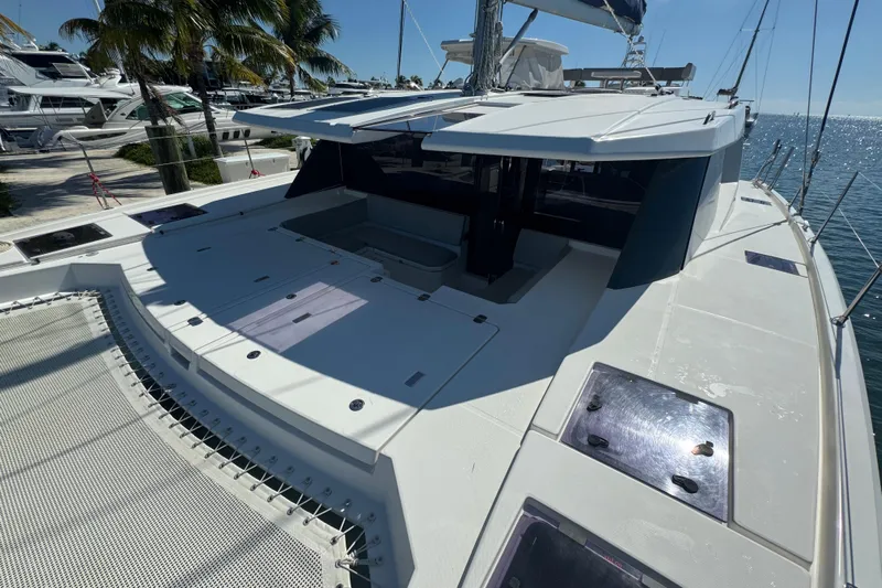 Ce Ya Yacht Photos Pics 2021 Leopard 45 catamaran deck with sleek design, docked near palm trees and ocean.