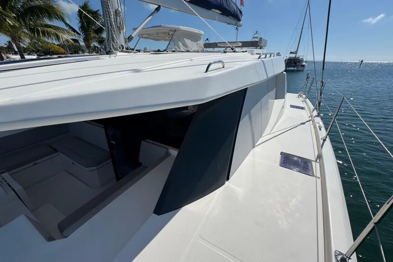 Ce Ya Yacht Photos Pics 2021 Leopard 45 yacht on calm water, showcasing sleek deck design and tropical backdrop.
