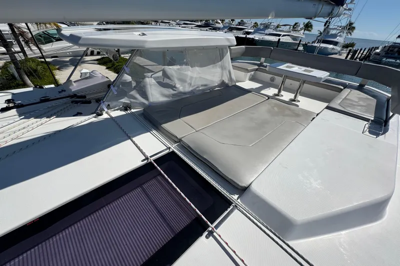 Ce Ya Yacht Photos Pics 2021 Leopard 45 yacht deck with seating and table, docked at marina.