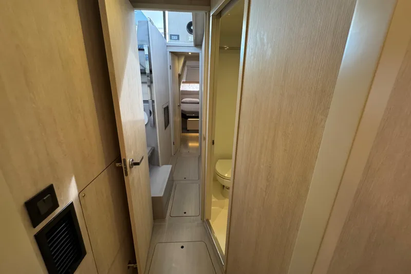 Ce Ya Yacht Photos Pics Interior hallway of 2021 Leopard 45 yacht, featuring light wood paneling and compact design.