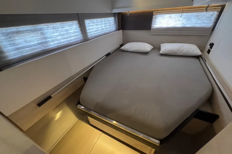 Ce Ya Yacht Photos Pics Interior of a 2021 Leopard 45 yacht cabin with a cozy bed and windows.