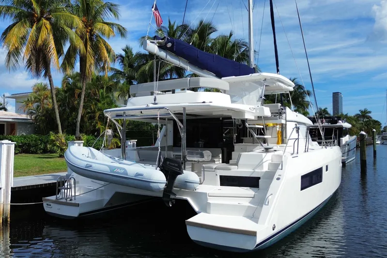 Ce Ya Yacht Photos Pics Luxury 2021 Leopard 45 catamaran docked by palm trees, featuring sleek design and spacious deck.