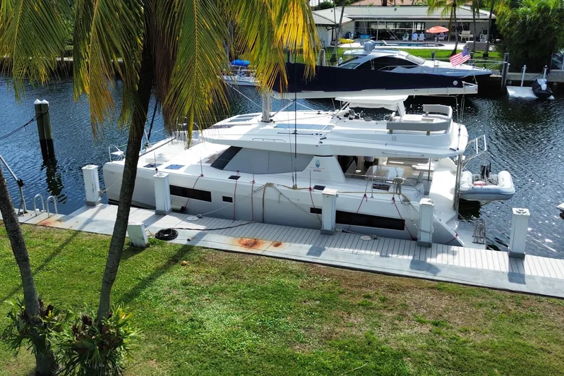 Ce Ya Yacht Photos Pics 2021 Leopard 45 catamaran docked by palm trees, featuring spacious deck and modern design.