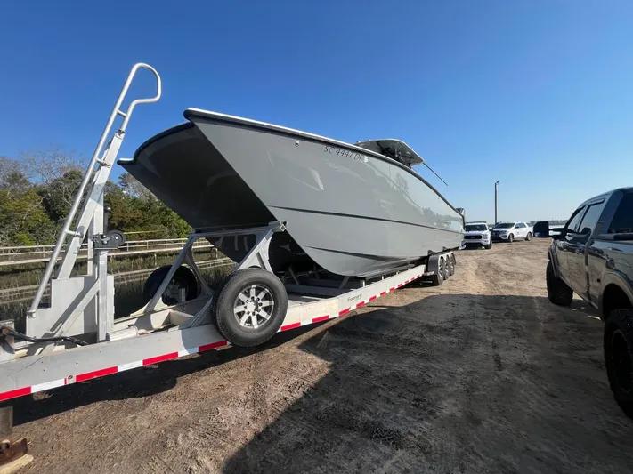  Yacht Photos Pics 2017 Freeman 37 VH boat on trailer, parked on dirt road under clear blue sky.
