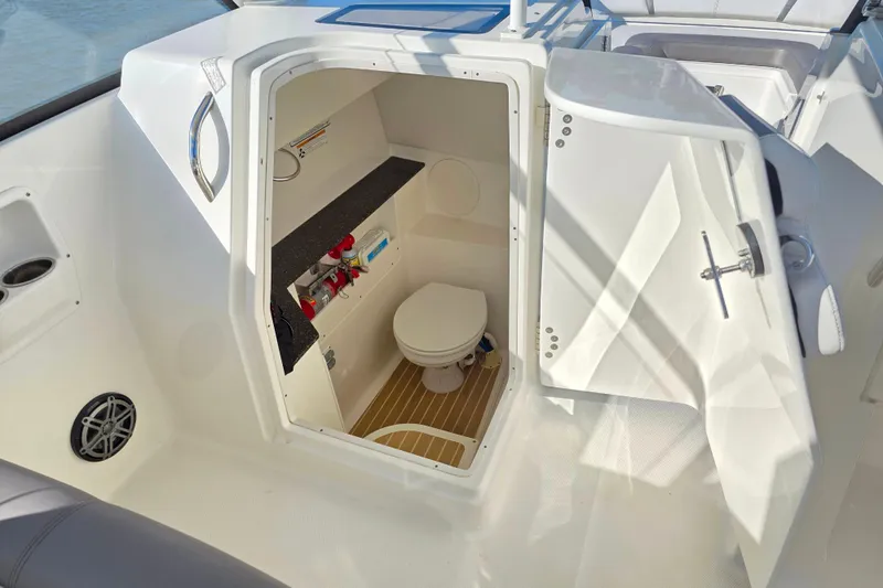  Yacht Photos Pics 2018 World Cat 280 DC-X boat interior with open door revealing compact marine toilet.