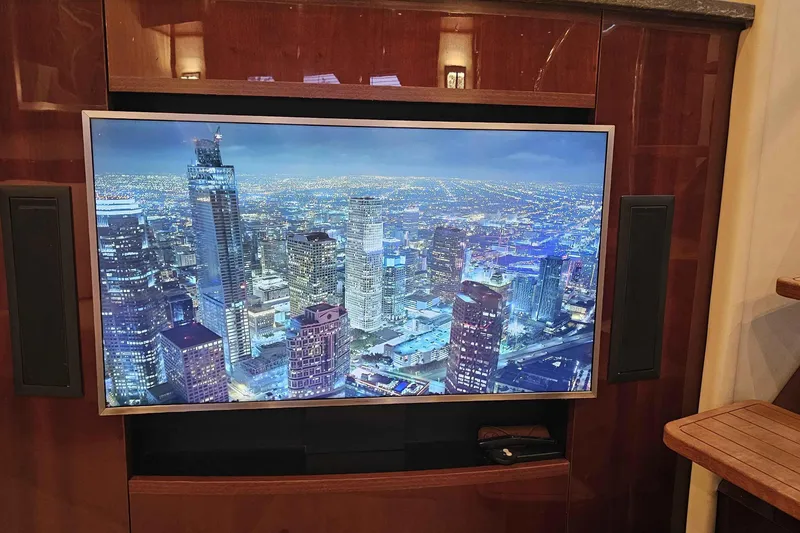  Yacht Photos Pics Luxurious 2007 Sea Ray 60 Sundancer interior with cityscape on TV screen.