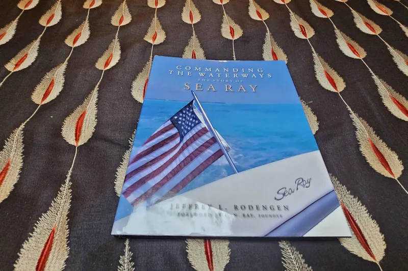  Yacht Photos Pics Book titled "Commanding the Waterways: The History of Sea Ray" on patterned fabric.