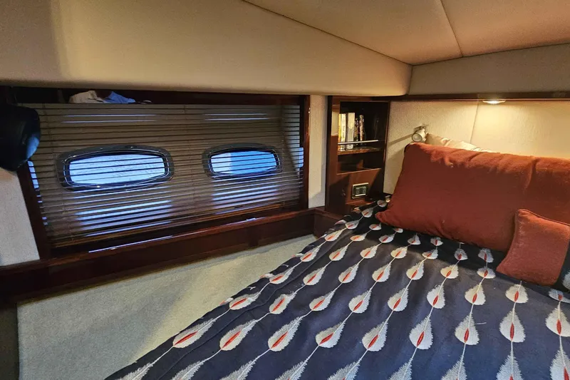 Yacht Photos Pics Cozy bedroom interior of 2007 Sea Ray 60 Sundancer yacht with patterned bedding and porthole windows.