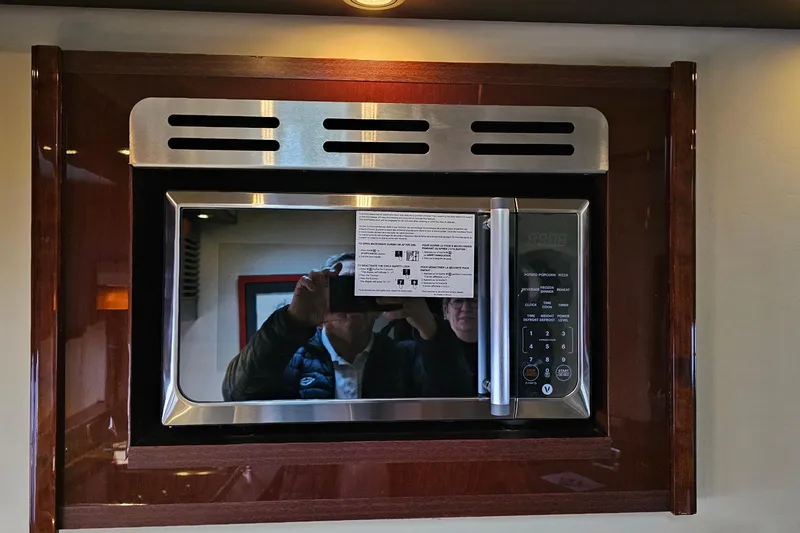  Yacht Photos Pics Microwave oven in 2007 Sea Ray 60 Sundancer yacht kitchen, with reflective surface and control panel.