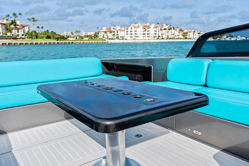 Daddy Yacht Photos Pics Luxurious 2015 VanDutch 55 yacht interior with turquoise seating and sleek table, coastal backdrop.