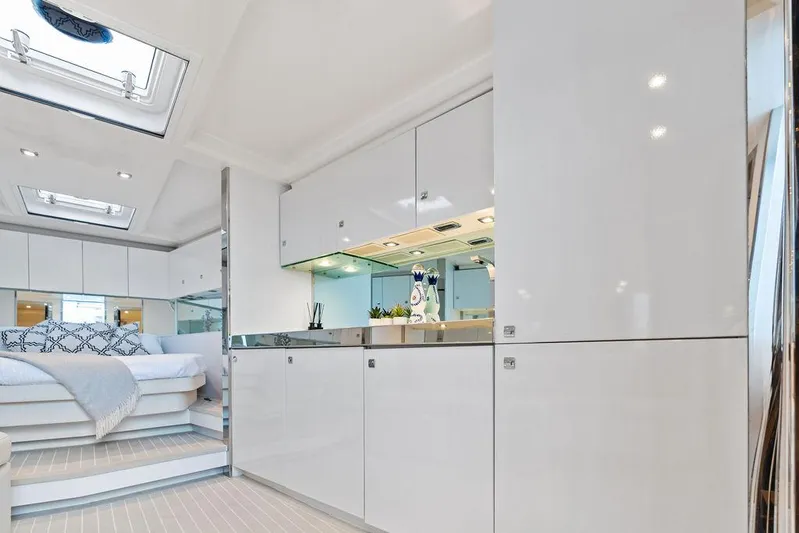 Daddy Yacht Photos Pics Luxurious interior of a 2015 VanDutch 55 yacht with modern white cabinetry and cozy bedroom.