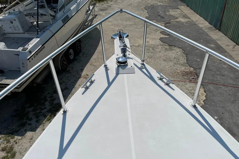 Lenore Yacht Photos Pics Bow view of 2023 Great Harbour Trawlers TT35, docked near another boat.