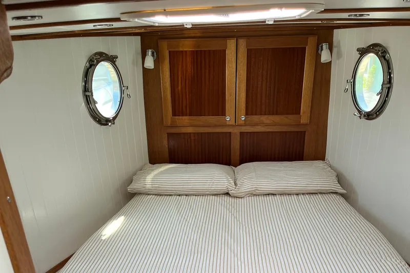 Lenore Yacht Photos Pics Cozy cabin interior of 2023 Great Harbour Trawlers TT35 with portholes and wooden accents.