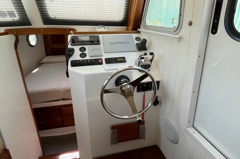 Lenore Yacht Photos Pics 2023 Great Harbour Trawlers TT35 helm with Garmin navigation, cozy cabin bed visible.