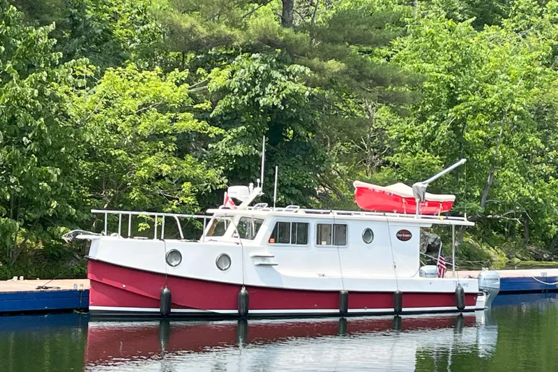 Lenore Yacht Photos Pics 2023 Great Harbour Trawlers TT35 docked by lush greenery.