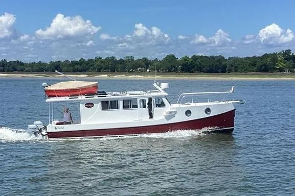 Lenore Yacht Photos Pics 2023 Great Harbour TT35 boat cruising on a calm lake under a clear blue sky.