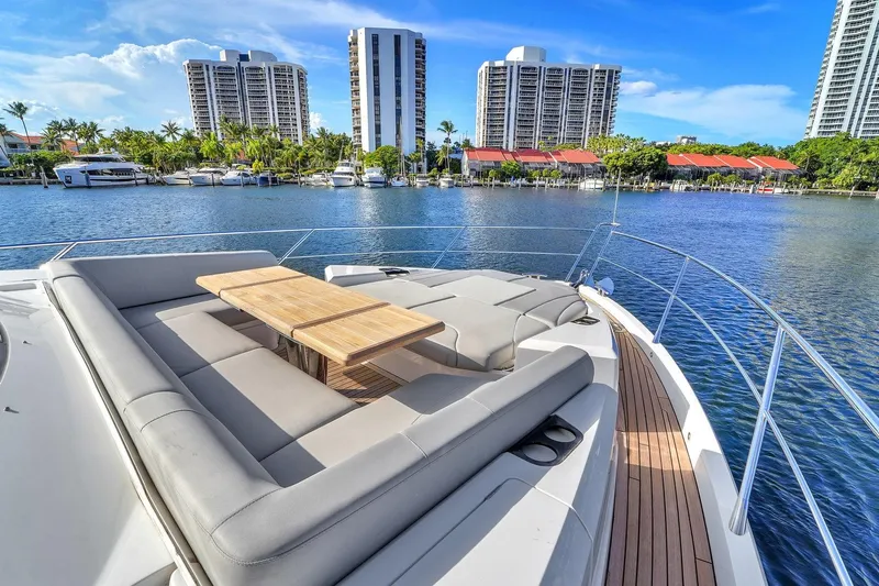  Yacht Photos Pics 2023 Sunseeker Manhattan 68 yacht deck with luxurious seating and scenic waterfront view.