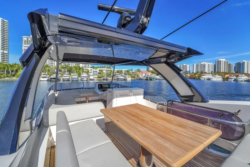  Yacht Photos Pics 2023 Sunseeker Manhattan 68 yacht with luxurious deck and waterfront cityscape.
