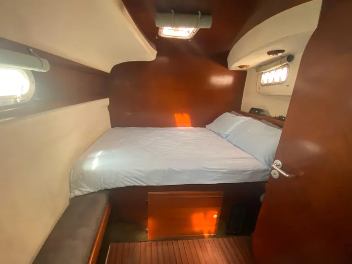Certitude Yacht Photos Pics Cozy cabin interior of 1998 Fountaine Pajot Bahia 46 catamaran with wooden finish and bed.