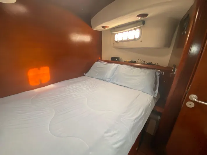 Certitude Yacht Photos Pics Cozy cabin interior of 1998 Fountaine Pajot Bahia 46 catamaran with bed and porthole.