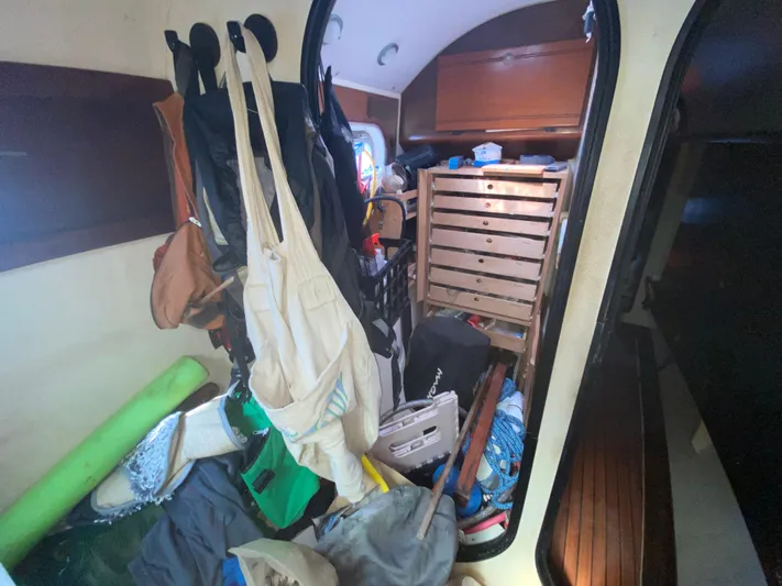 Certitude Yacht Photos Pics Cluttered interior of 1998 Fountaine Pajot Bahia 46 sailboat with storage and hanging items.