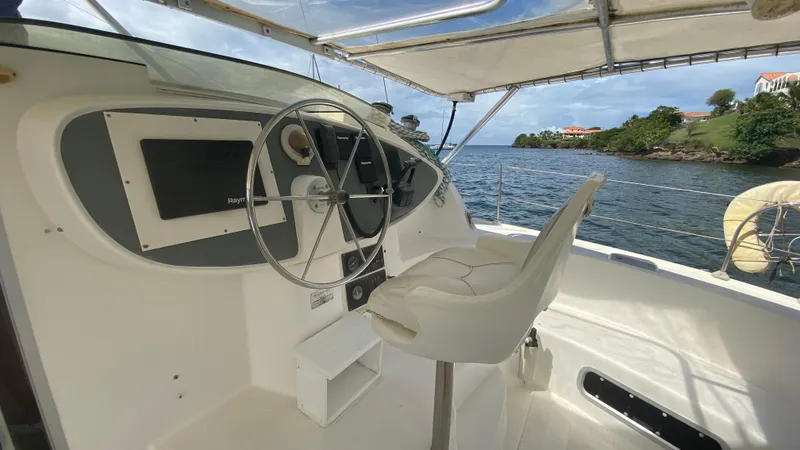 Certitude Yacht Photos Pics Helm of 1998 Fountaine Pajot Bahia 46 catamaran with ocean view and coastal background.